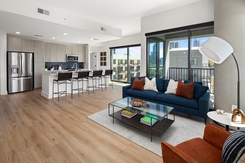 a living room and kitchen with a blue couch and a coffee table